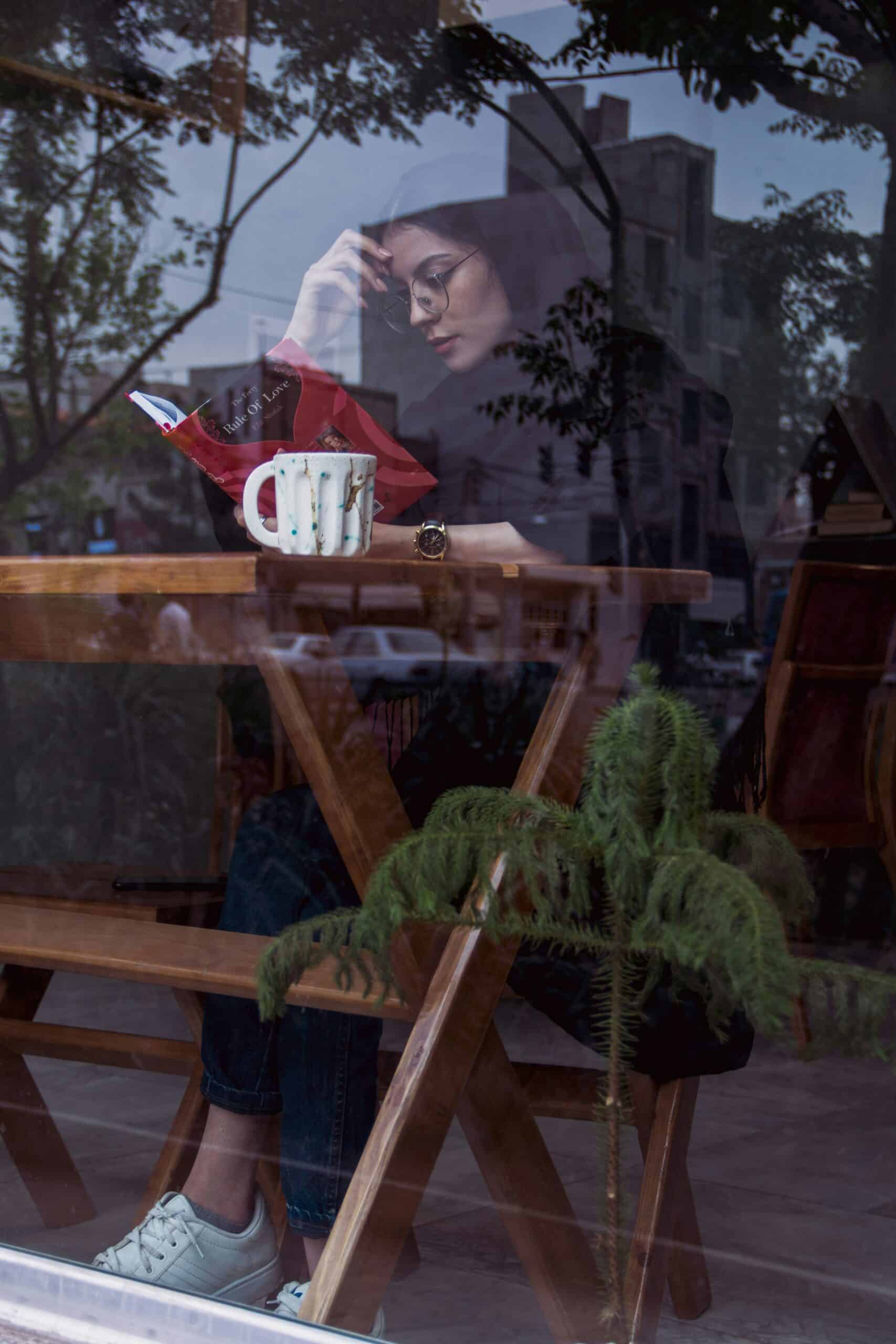 A cozy reading corner with books stacked beside a cup of tea.